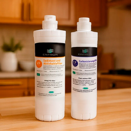 Das Osmose Ersatzfilter-Set bestehend aus: Sediment- und Aktivkohlefilter und Carbonisierungsfilter für die Entron F-Serie - stehend in einer warmen Küche